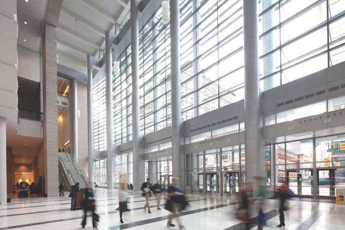 Large convention center lobby with floor to ceiling windows broken up by a grid of dividers