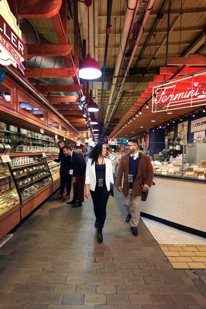 Brightly lit interior of a food market with a happy couple strolling and taking in the sights